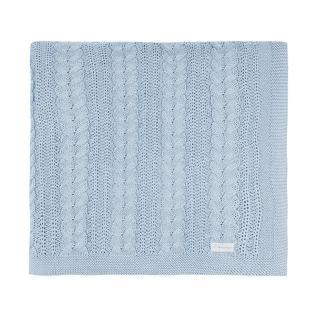manta sorrento de tricô azul bebê dobrada, com textura em tranças e ponto rendado, etiqueta discreta no canto
