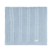 manta sorrento de tricô azul bebê dobrada, com textura em tranças e ponto rendado, etiqueta discreta no canto