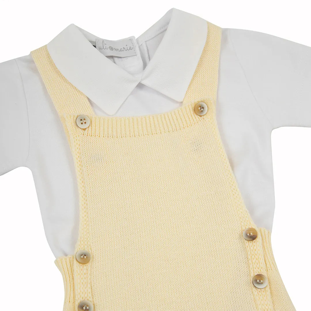 romper capri amarelo bebê com botões de madeira e body branco básico de gola polo sobre fundo isolado