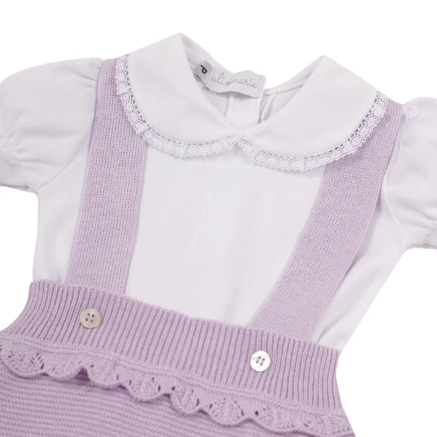 romper malu lilás com barra e cintura onduladas e suspensórios, sobre body branco com gola de renda