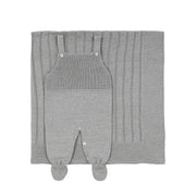 saída maternidade bambu cinza com jardineira de tricô em frente a manta com detalhes em listras verticais