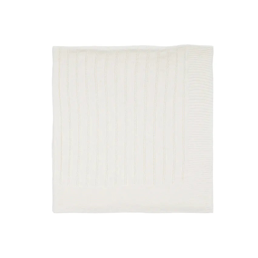 saída maternidade bambu off-white com jardineira de tricô em frente a manta com detalhes texturizados e botões brancos