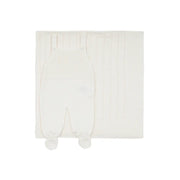 saída maternidade bambu off-white com jardineira de tricô em frente a manta com detalhes texturizados e botões brancos