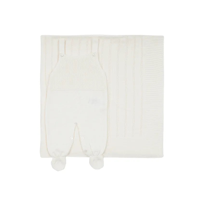 saída maternidade bambu off-white com jardineira de tricô em frente a manta com detalhes texturizados e botões brancos