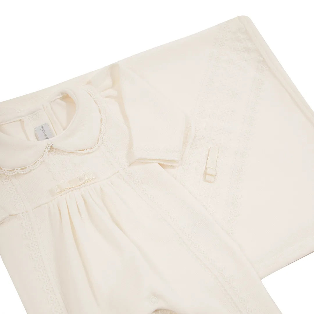 vista inclinada do conjunto de saída maternidade cecília off-white, mostrando o macacão e a manta com detalhes de renda