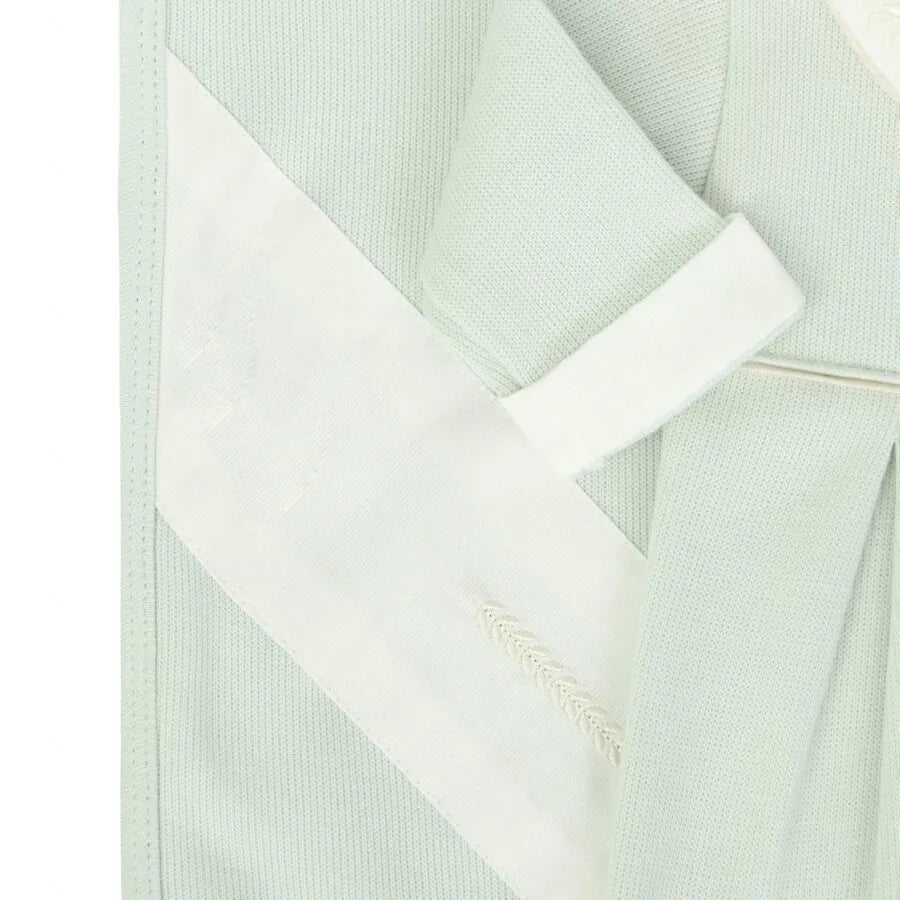 detalhe da manta e da manga da saída maternidade clássica verde malva com faixa branca e bordado em ponto folha