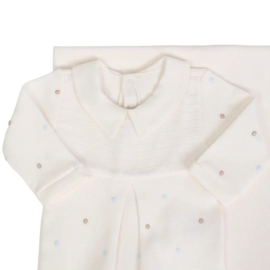 Macacão off-white com pala canelada e gola lisa, detalhes de poás bordados em azul claro e bege, acompanhado da manta do conjunto
