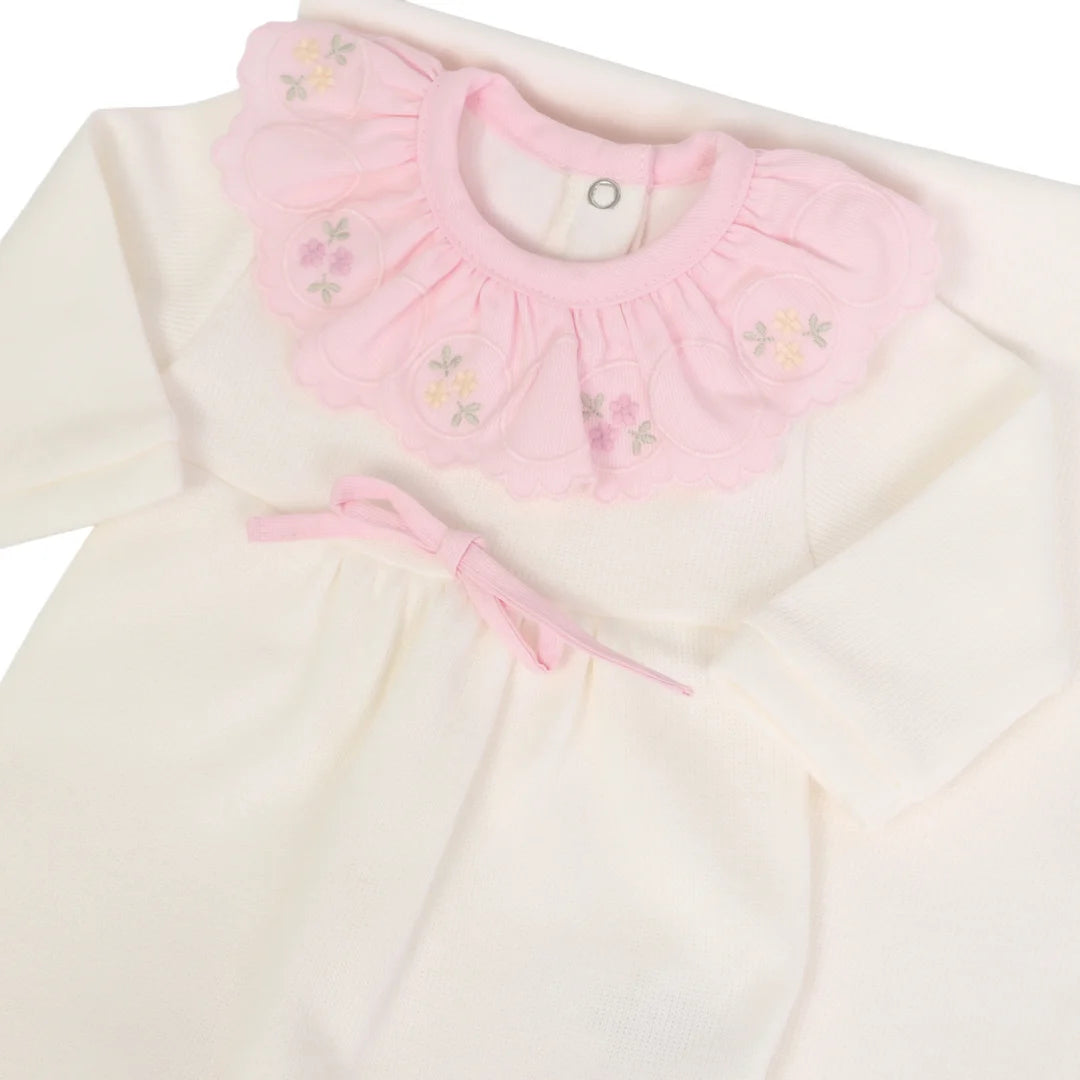 macacão melina off-white com gola babado rosa bordada e laço rosa visto em detalhe lateral