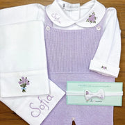 saída maternidade sofia personalizada lilás com jardineira em tricô, body bordado floral e manta com nome e laço