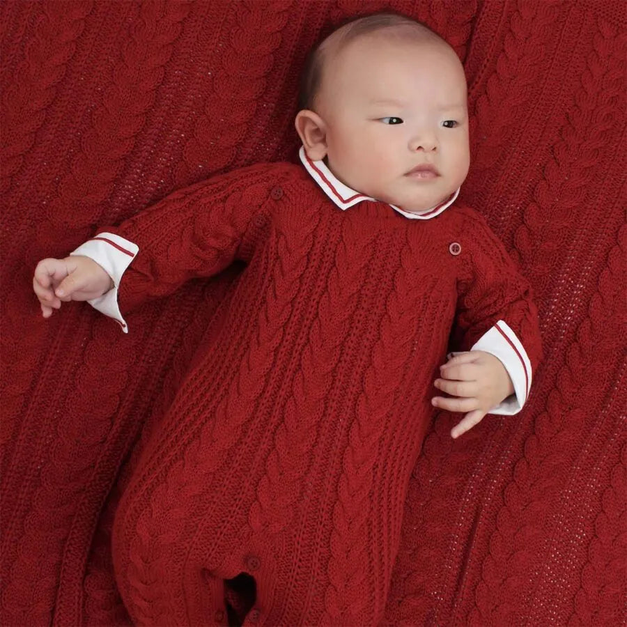 saída maternidade sorrento vermelha composta por macacão em tricô com padrão trançado e manta combinando, perfeita para o primeiro look do bebê