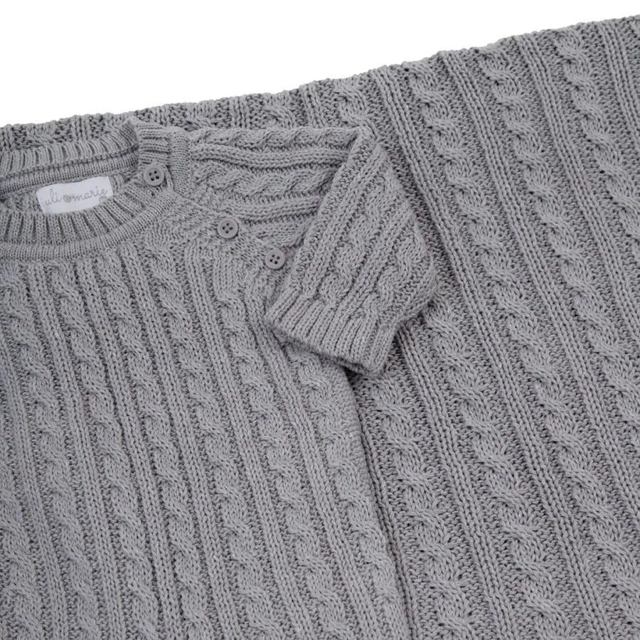 saída maternidade uli cinza composta por macacão em tricô com tranças delicadas e manta coordenada, ideal para o primeiro dia do bebê